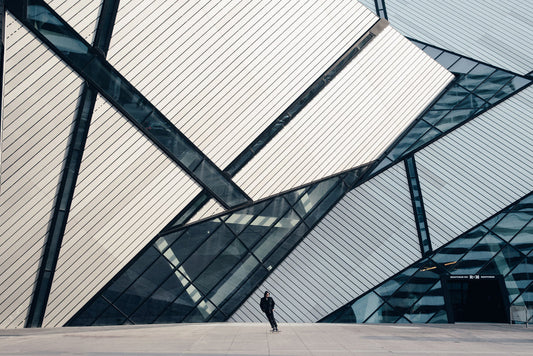 A skateboarder rides in front of the Royal Ontario Museum: a building with architecture reminiscent of an abstract painting.
