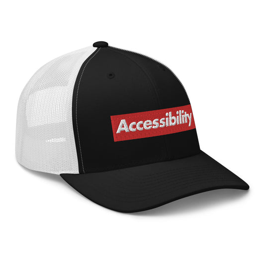 Angle view of black front trucker hat shows text logo design on front of hat with white mesh backing.